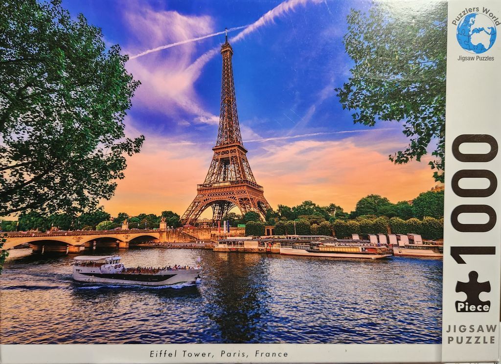 The Eiffel Tower in Paris at sunset with a boat on the Seine river