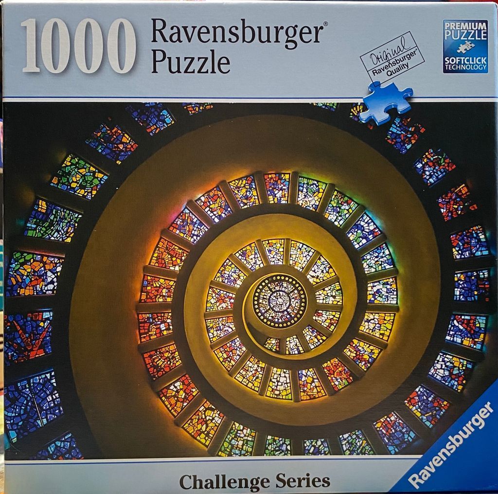 A low-angle, spiraling view looking up into a cathedral dome decorated with colorful stained glass panels.