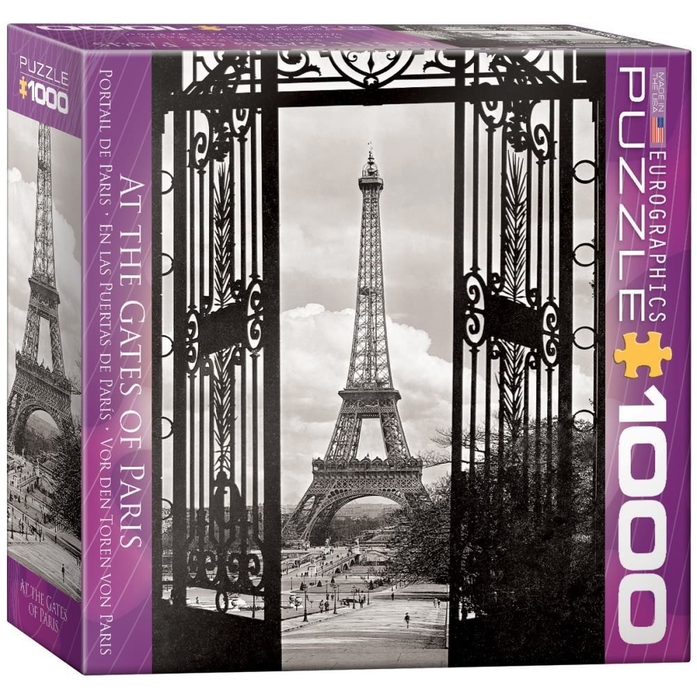 A black and white photograph of the Eiffel Tower framed by an ornate wrought iron gate.