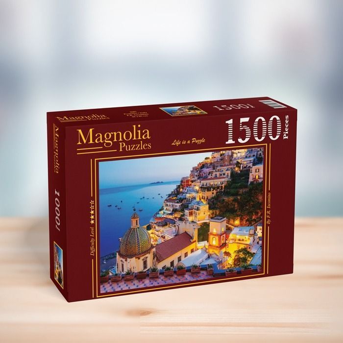 A twilight view of the cliffside village of Positano, Italy, featuring a domed church and cascading colorful houses.
