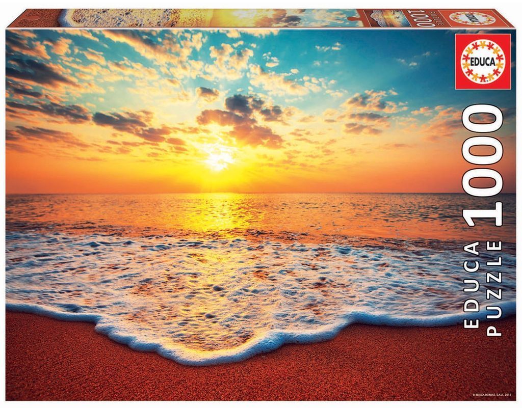 A scenic photograph of a bright golden sunset over a calm ocean beach.