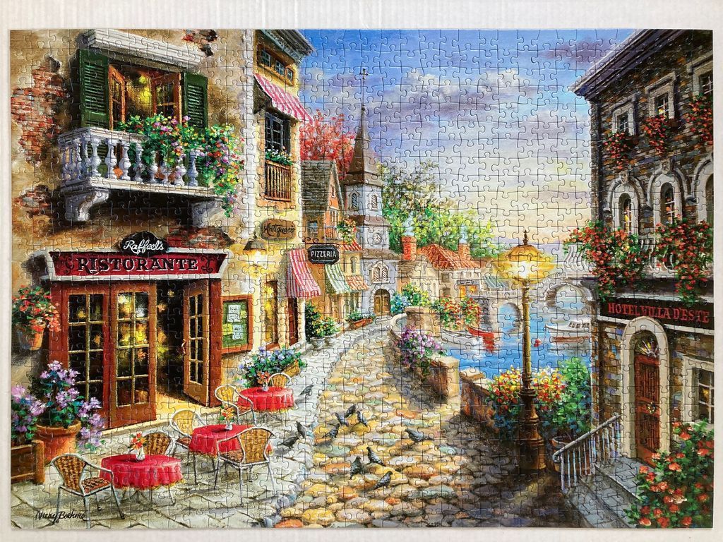 A scenic Italian village street scene with a restaurant, stone buildings, and a canal