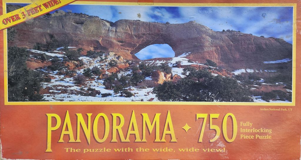 A panoramic landscape photograph of a large natural sandstone arch in Arches National Park, Utah, in winter.