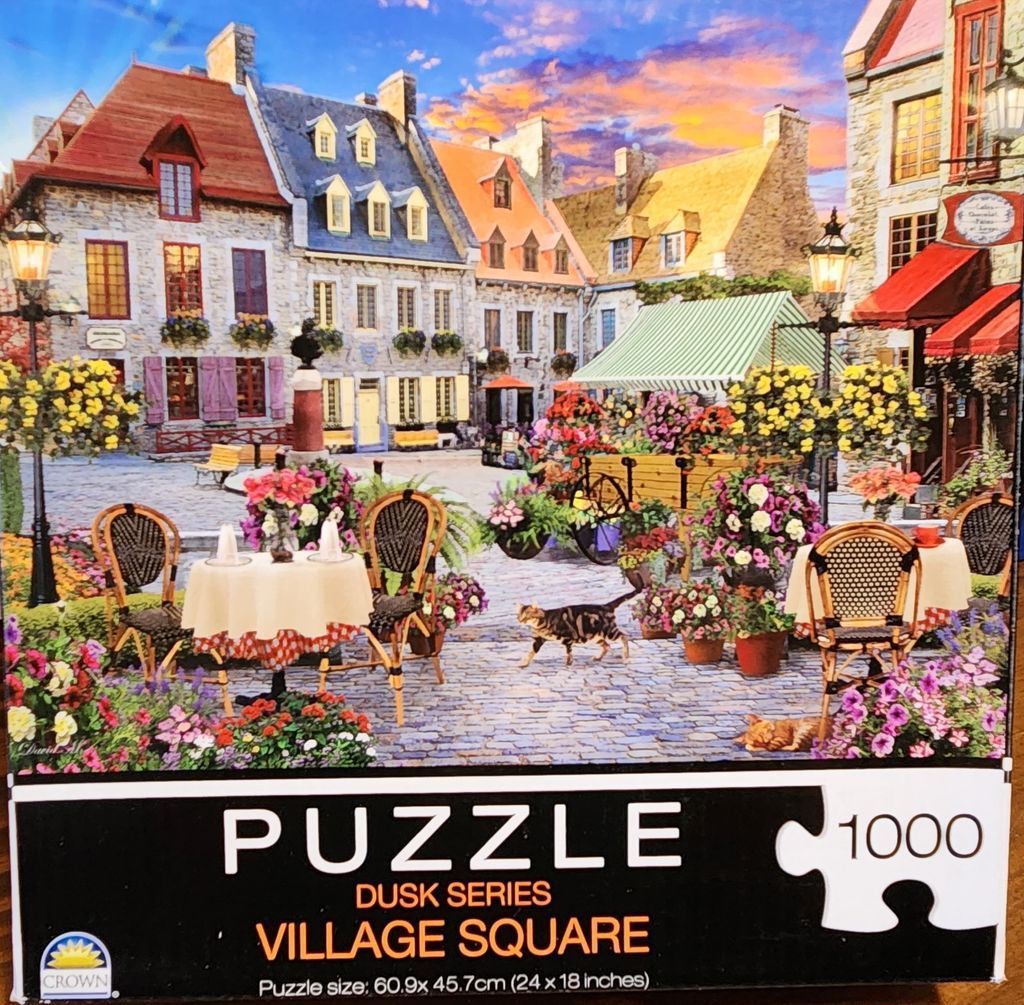 An illustration of a quaint European-style village square at sunset with outdoor café seating, flowers, and a cat.