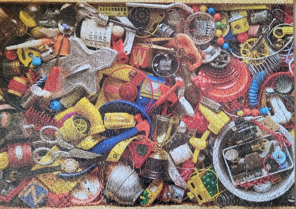 A dense, colorful collection of miscellaneous vintage objects, trinkets, toys, and household tools packed together.