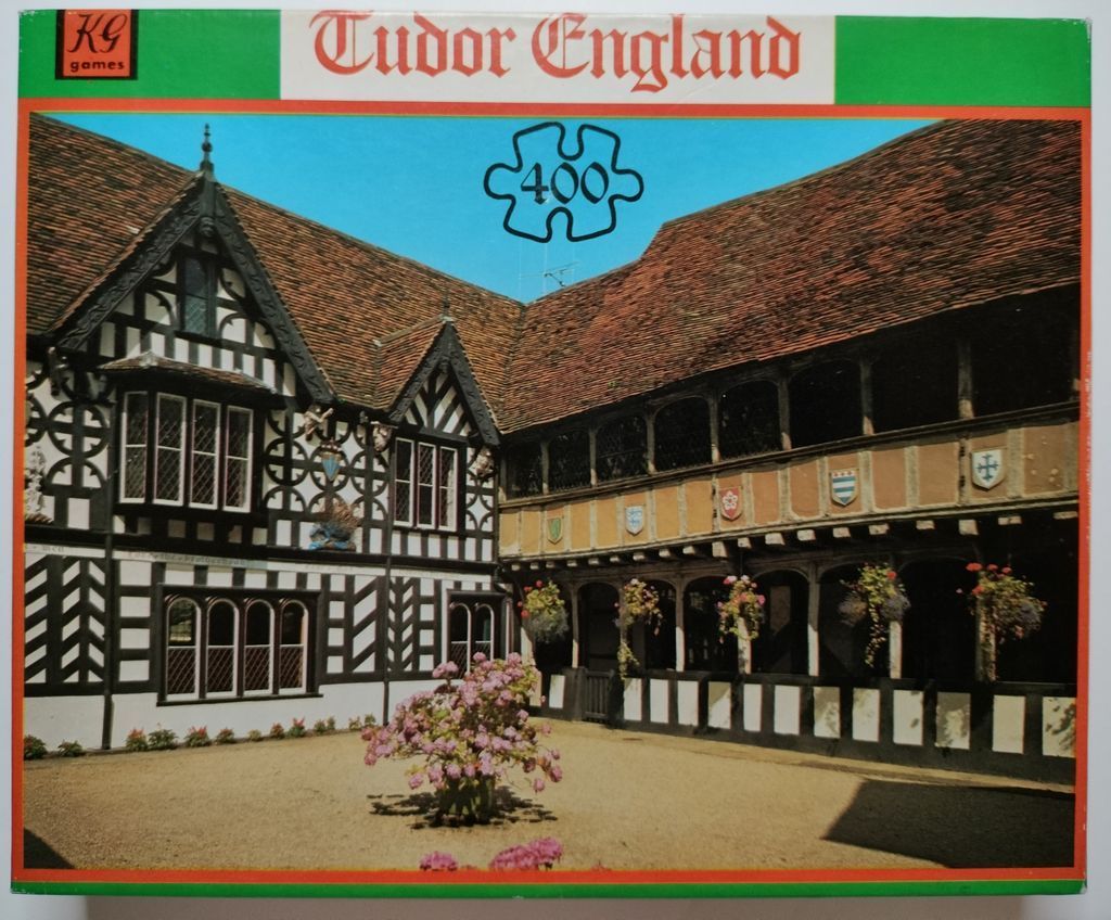 A photograph of the courtyard of a historic timber-framed Tudor building with black and white beams and a gravel ground.