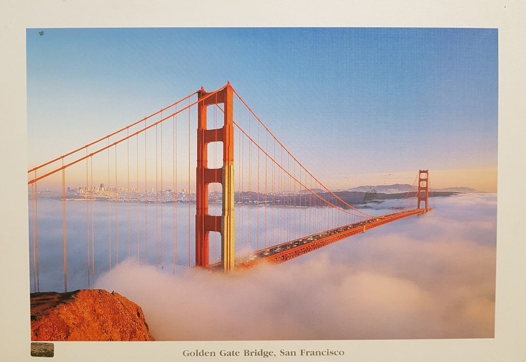 The Golden Gate Bridge in San Francisco rising above a thick layer of fog at sunrise.