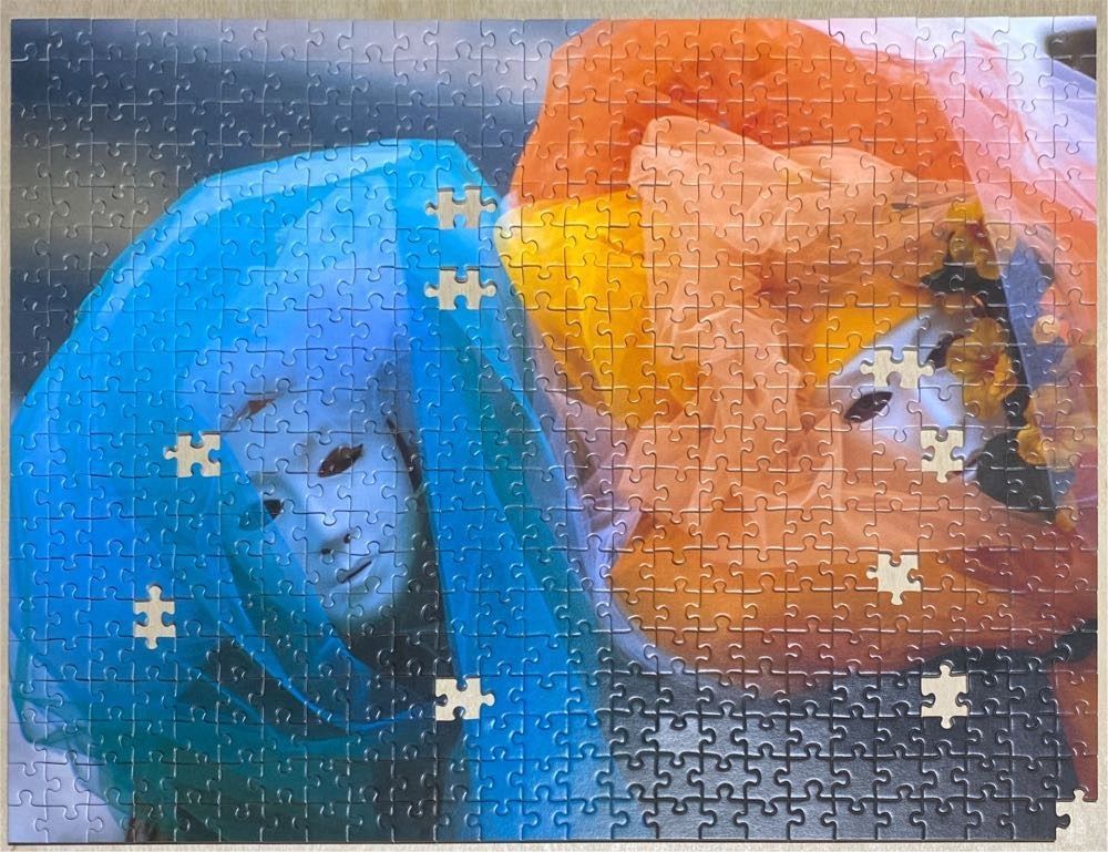 Two Venetian-style masquerade masks draped in sheer blue and orange fabrics.