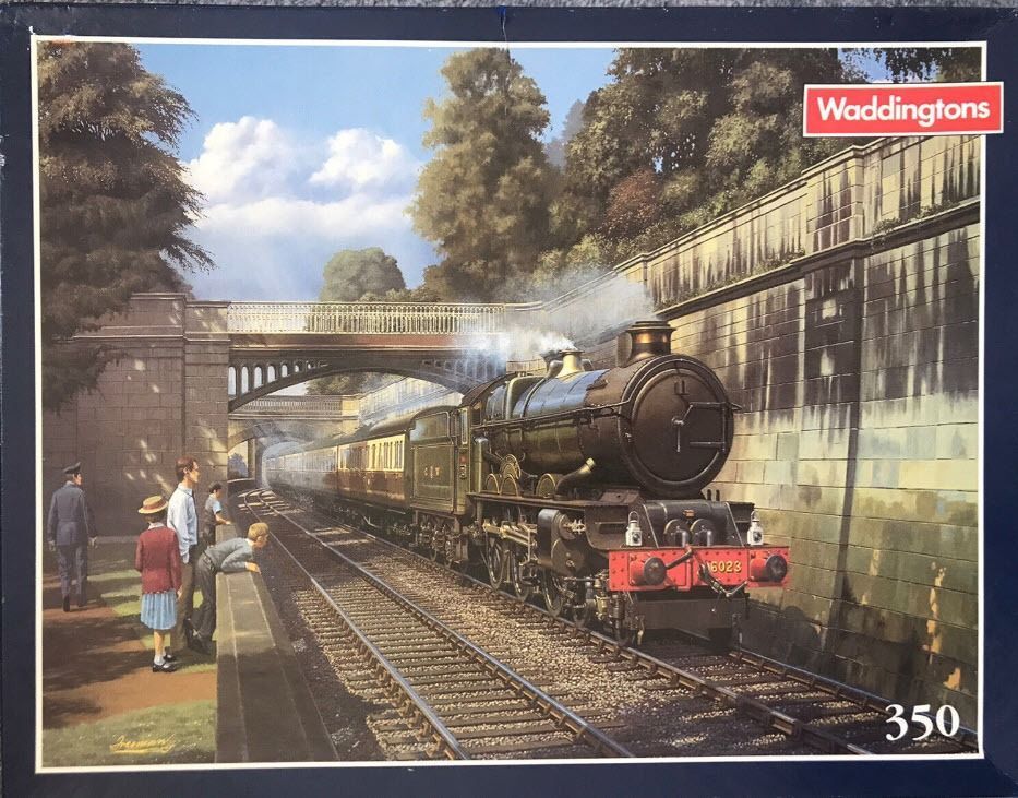 A steam train arriving at a platform with onlookers in a vintage setting.