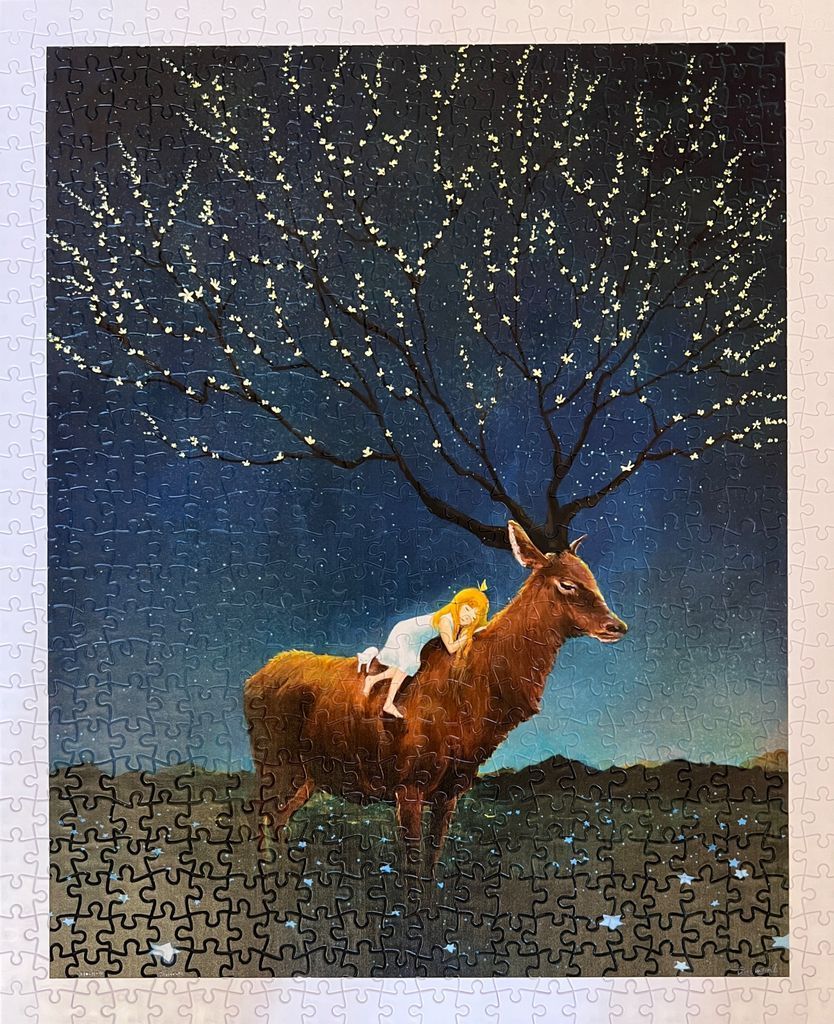 A girl with blonde hair sleeps on a deer beneath a starry, blooming tree at night.
