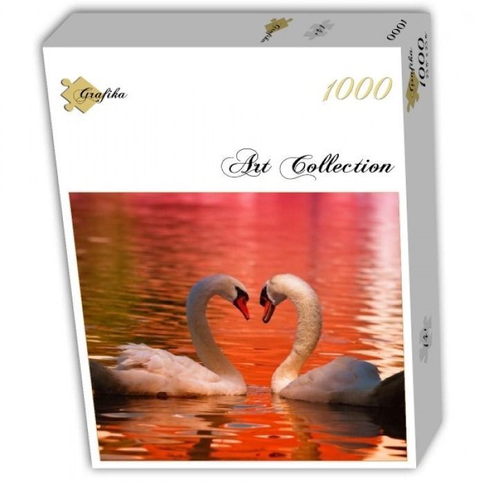 Two white swans facing each other to form a heart shape on a vibrant, sunset-lit lake.