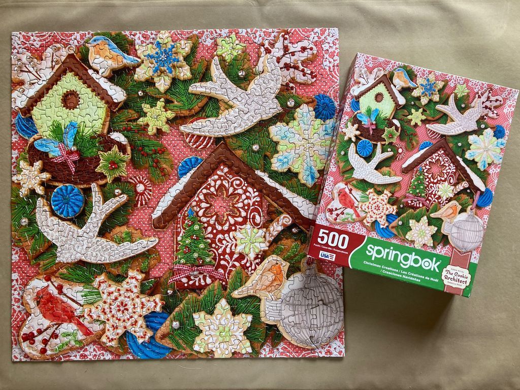 A whimsical collage of decorative Christmas cookies shaped like birds, snowflakes, and gingerbread houses.