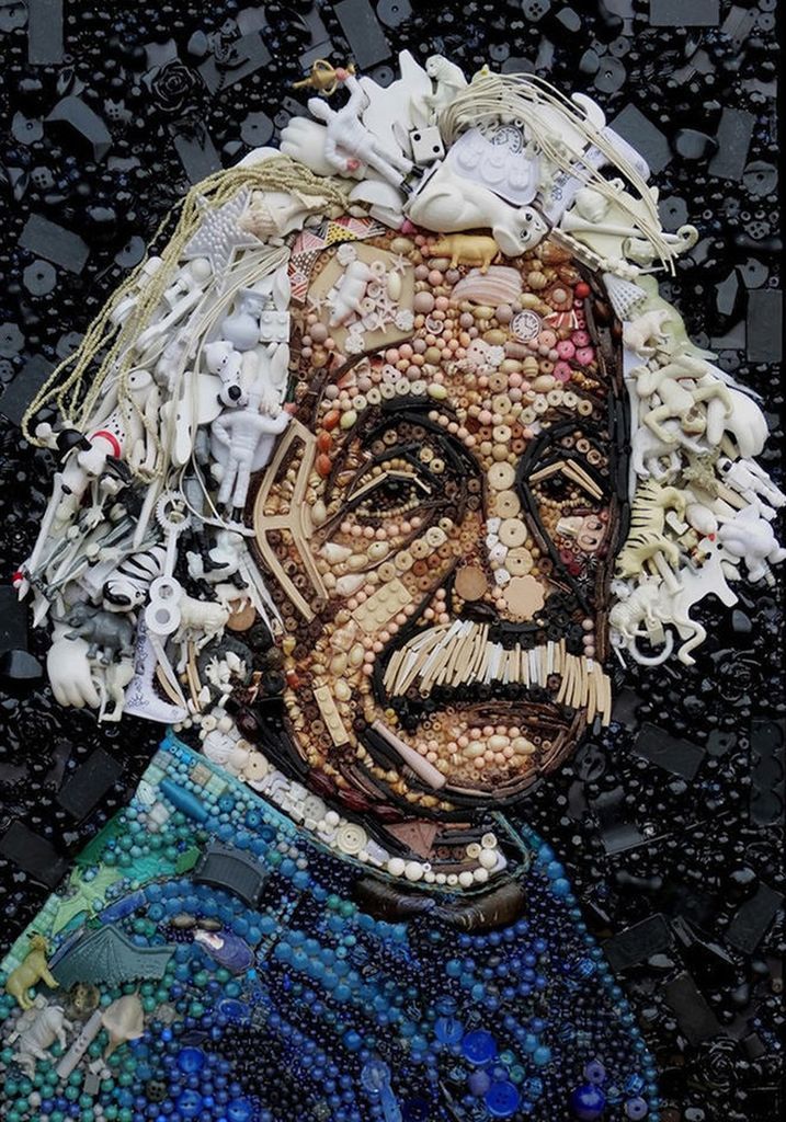 A mosaic portrait of Albert Einstein created from found objects and toys against a black background.