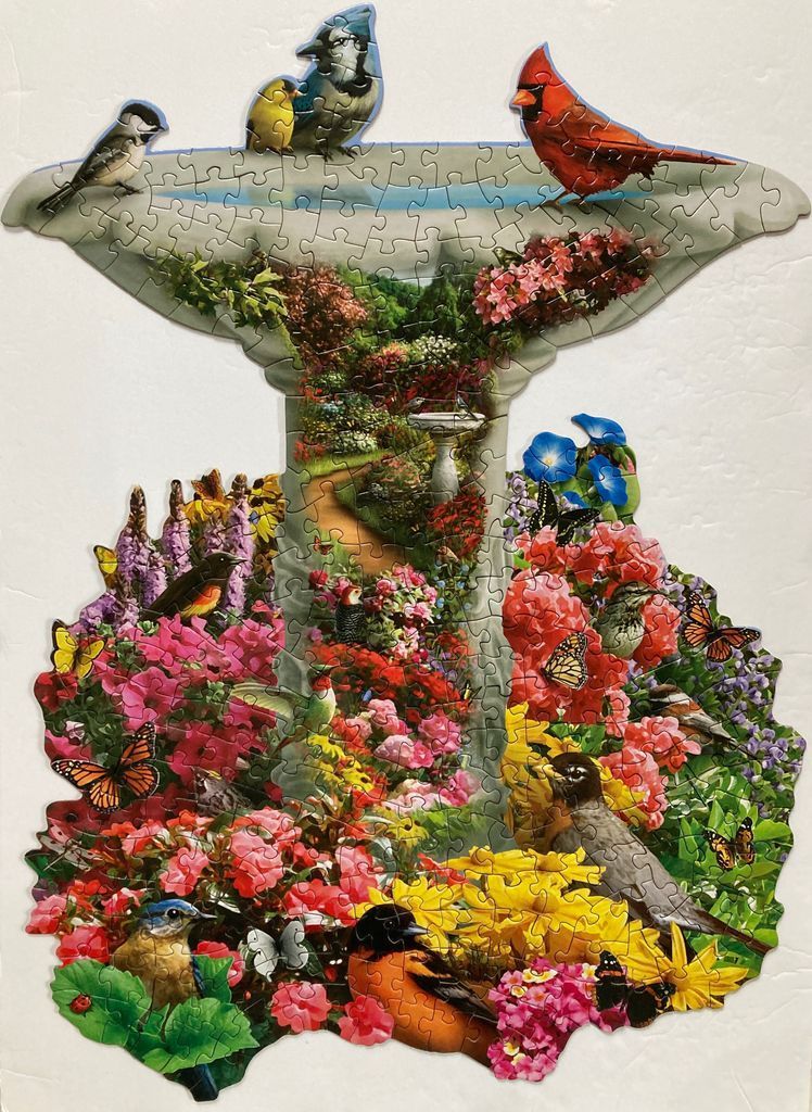 Shaped image of a birdbath overflowing with a vibrant, flower-filled garden scene featuring many birds and butterflies.