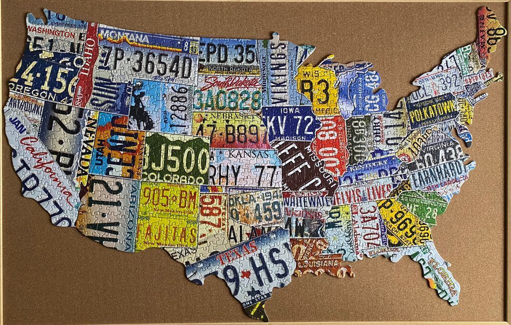 A map of the United States formed by a collage of vintage license plates from various states.