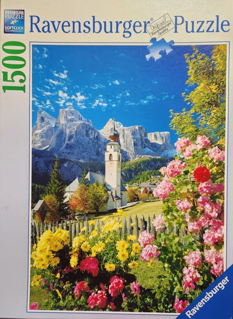 A scenic view of a church in the Italian Dolomites with colorful flowers in the foreground.