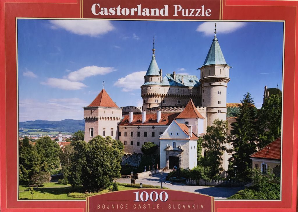 Bojnice Castle in Slovakia featuring fairy-tale turrets and red-tiled roofs under a bright blue sky.