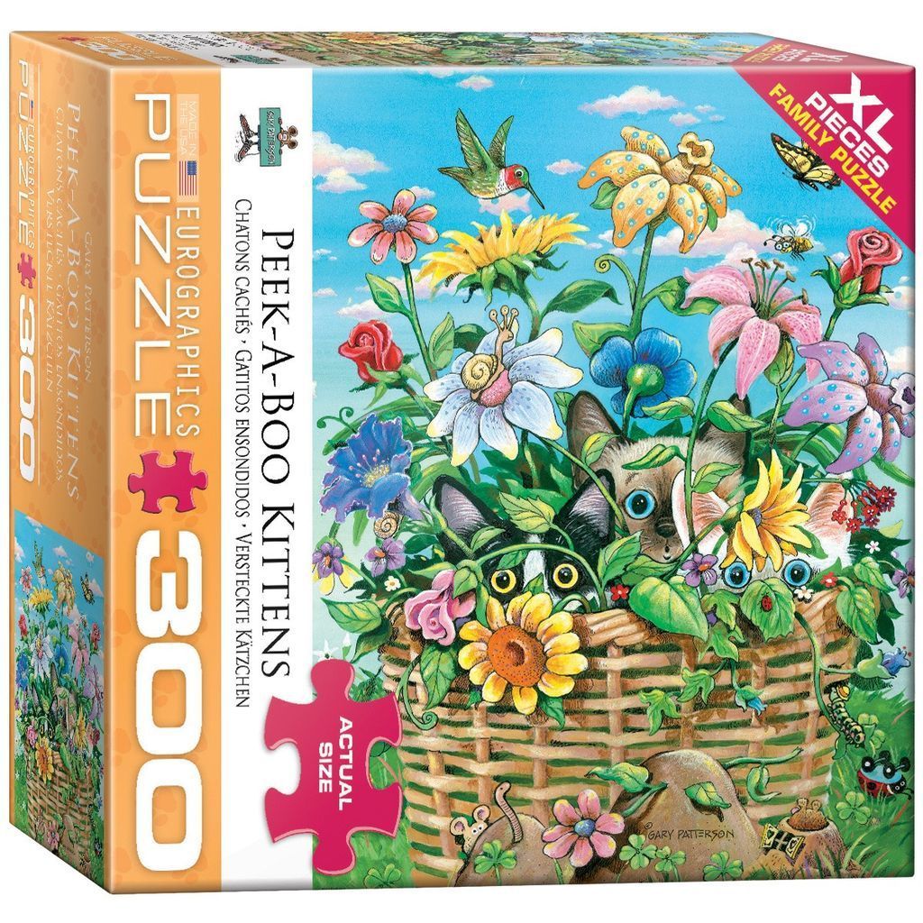 Three kittens peeking out from a woven wicker basket filled with colorful flowers and greenery.