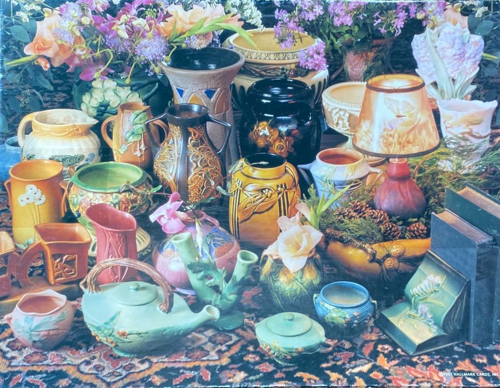 A collection of vintage majolica-style pottery and lamps arranged on a patterned rug