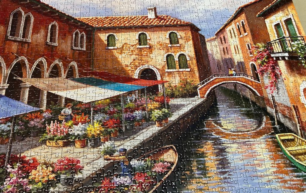 An oil painting of a vibrant canal-side flower market in Venice featuring arched buildings and a stone bridge.