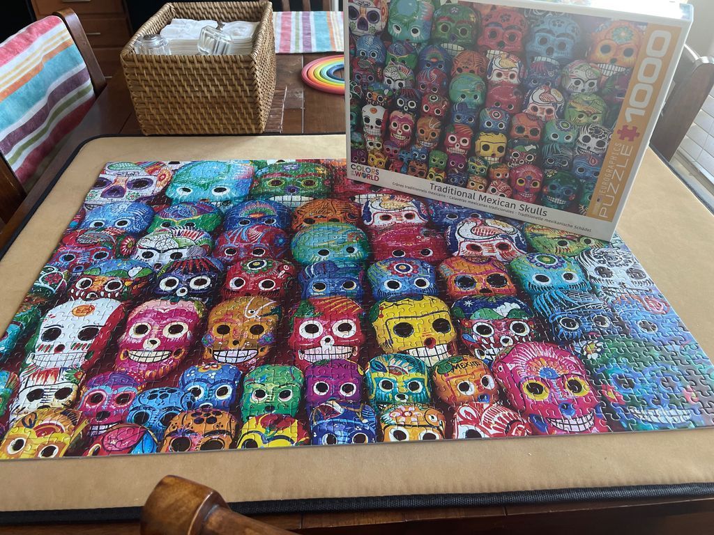 An arrangement of vibrant, decorative Mexican sugar skulls in a grid pattern.