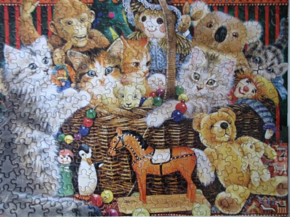 A whimsical illustration of various kittens and plush toys sitting inside and around a woven wicker basket.