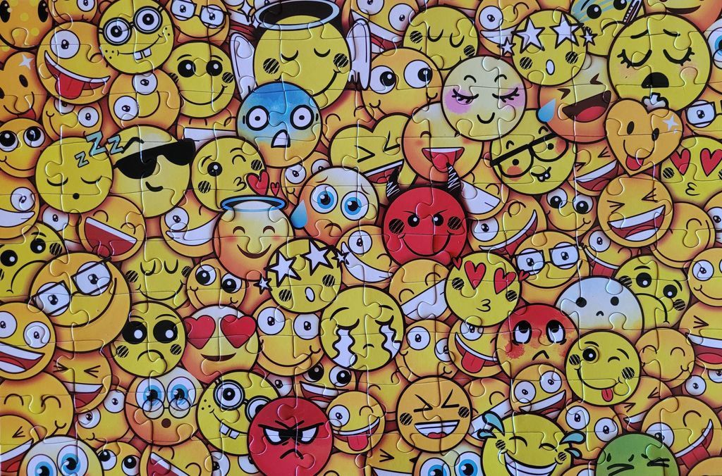 A dense pattern of various yellow emoji faces with different expressions and features.