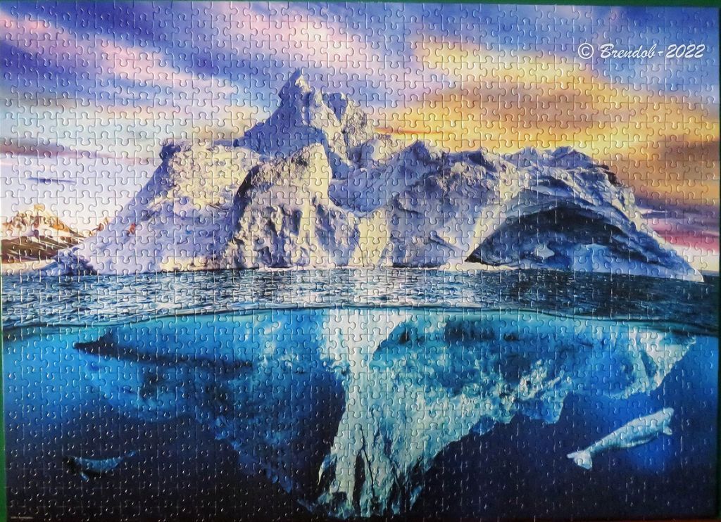 A split-view illustration of a massive iceberg above and below the deep blue ocean water at sunset.