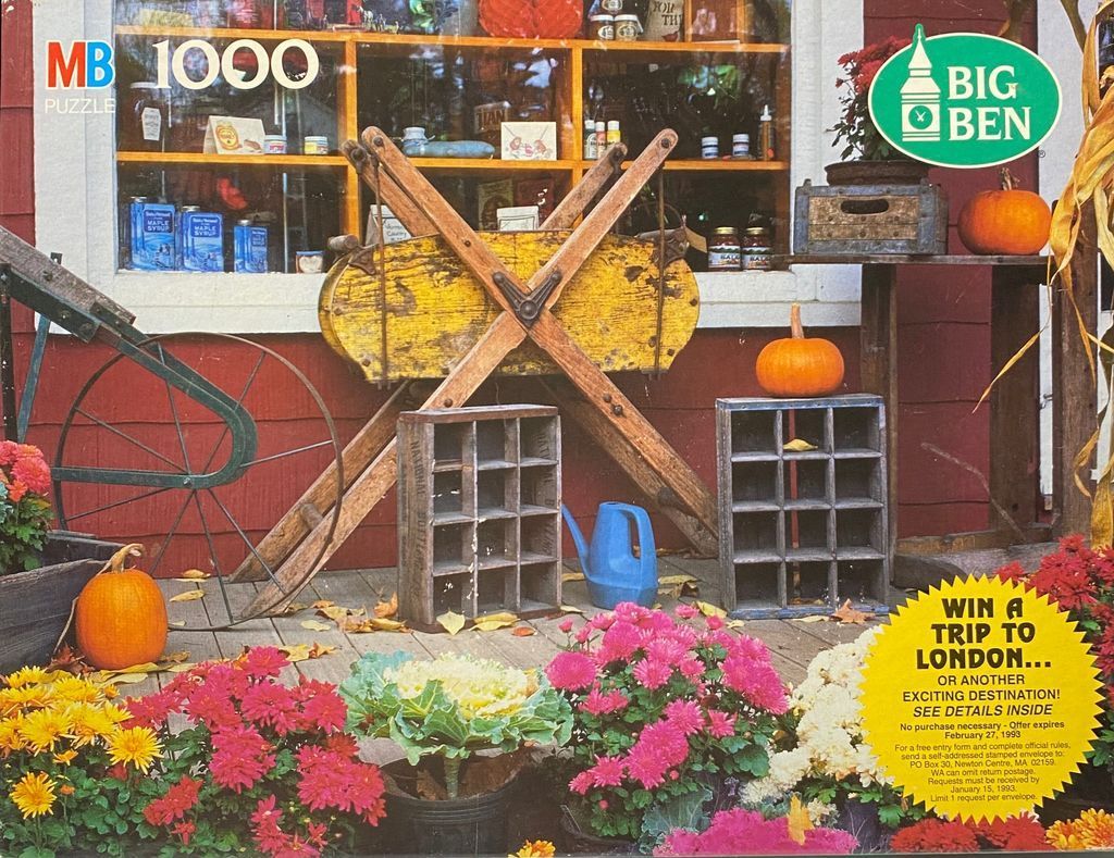 A rustic country store porch decorated with pumpkins, wooden crates, and autumn flowers.