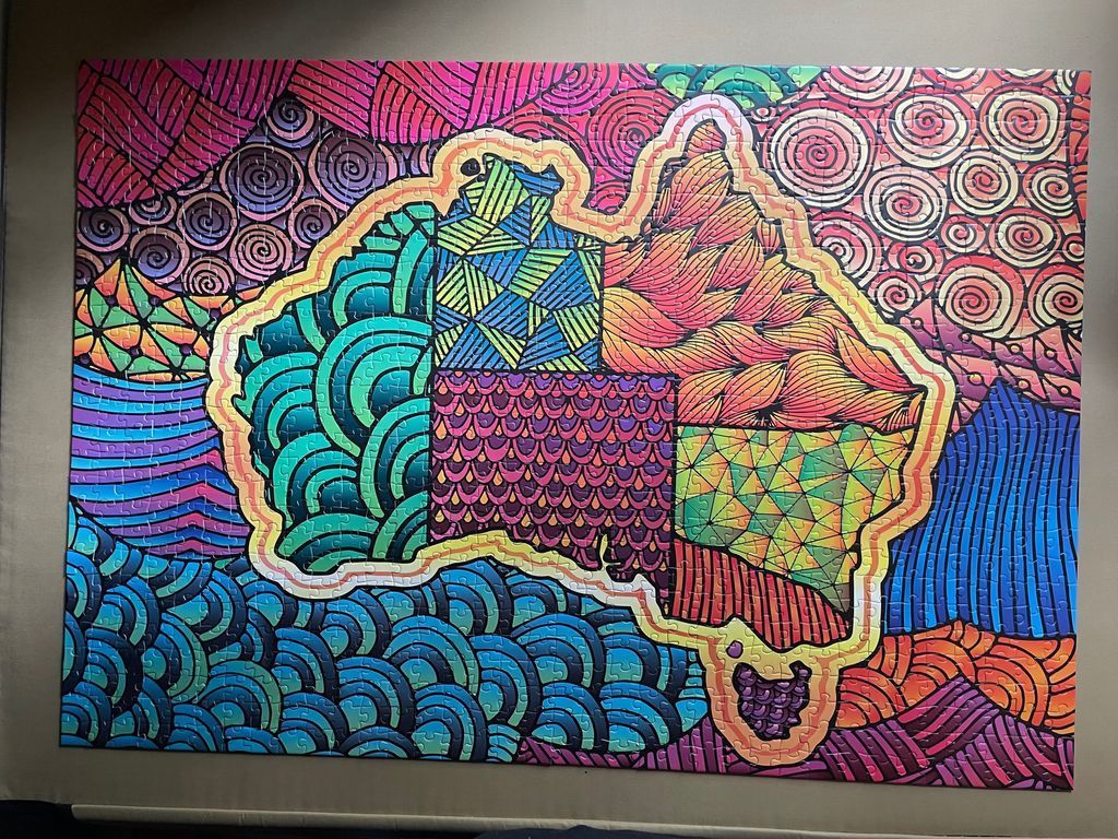 A stylized map of Australia filled with colourful geometric and organic patterns.