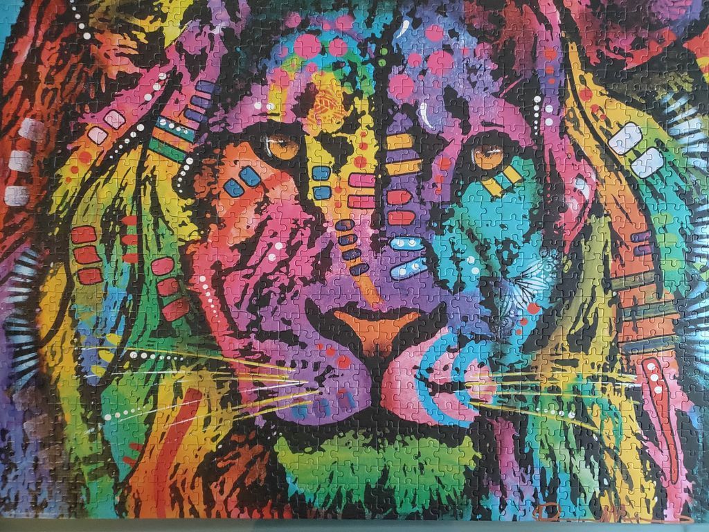 Pop art style close-up portrait of a lion with vibrant, multi-colored abstract patterns.