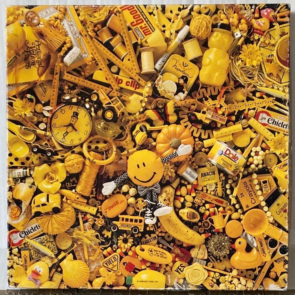 A cluttered collage of numerous yellow objects, toys, and household items organized into a dense, monochromatic scene.