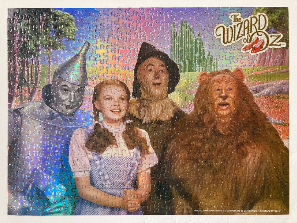 The four main characters from The Wizard of Oz standing in front of the Emerald City.