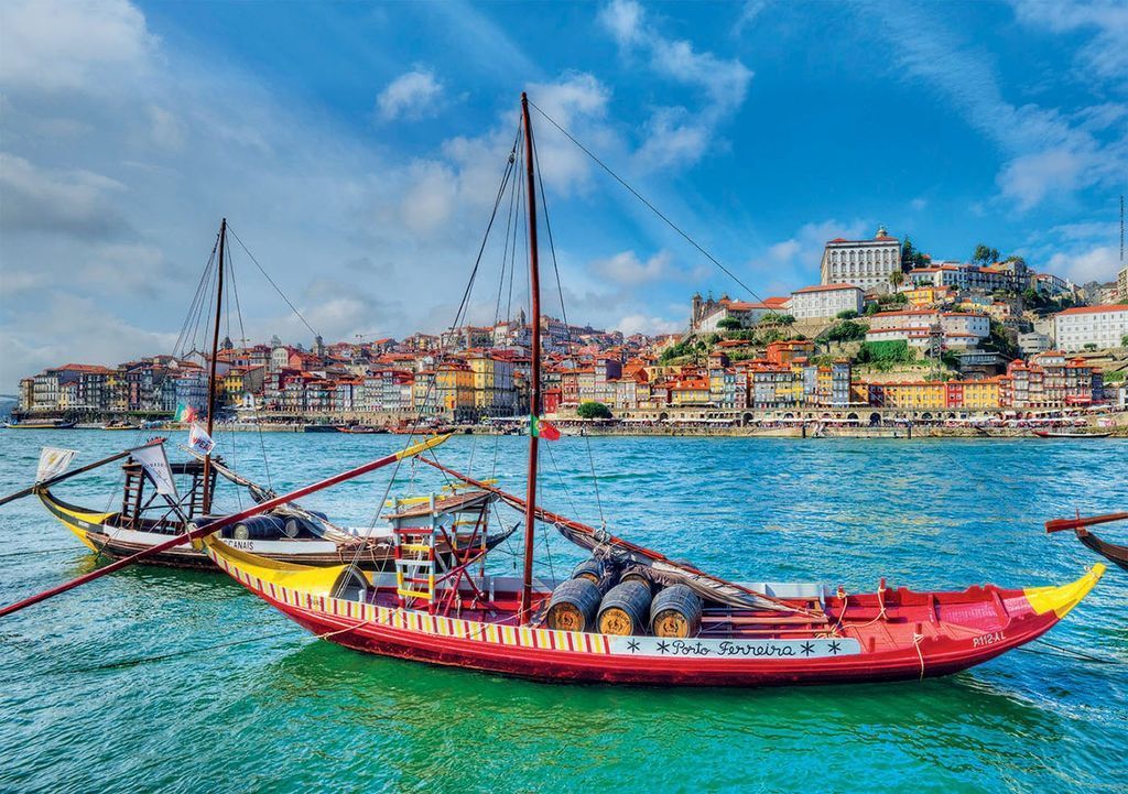 Two traditional wooden boats with barrels on the Douro River with the Porto cityscape in the background.