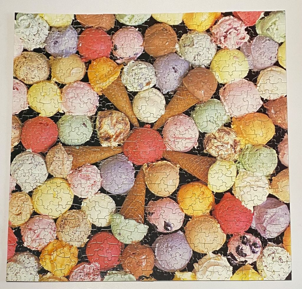 A collection of colorful scoops of ice cream on cones arranged against a solid black background.
