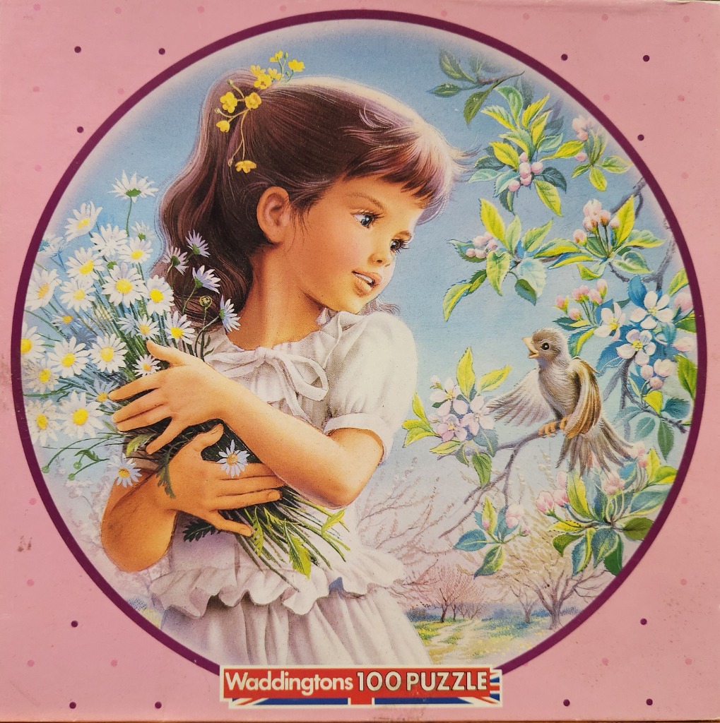 A young girl with brown hair holds a bouquet of daisies and looks at a small bird perched on a blossoming tree branch.