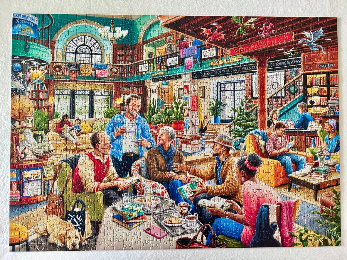 A detailed illustration of a cozy bookstore café filled with people reading and talking, with dragons overhead.