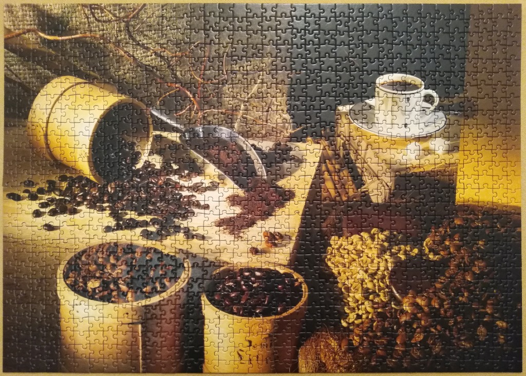 Still life photography featuring a cup of coffee and coffee beans in rustic containers.