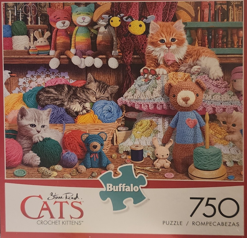 A cozy scene featuring live kittens and crocheted toys surrounded by balls of yarn in a craft room.