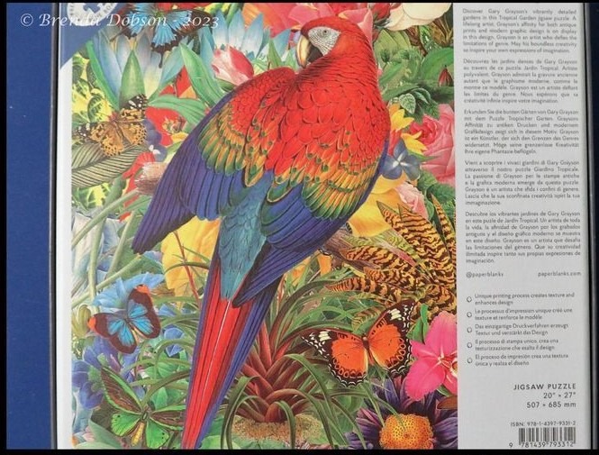 Vibrant scarlet macaw perched amidst lush tropical foliage and colorful butterflies.
