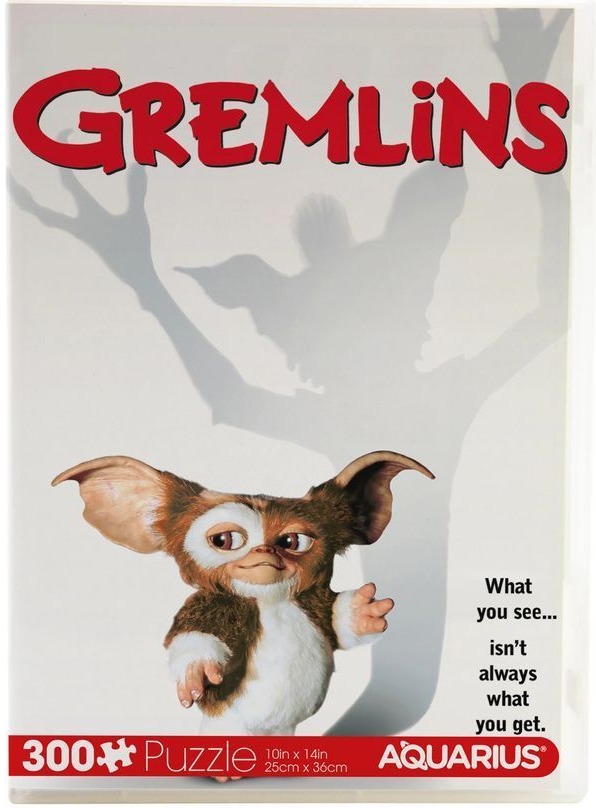 A close-up of a furry creature named Gizmo casting a tall, monstrous shadow on a white background.