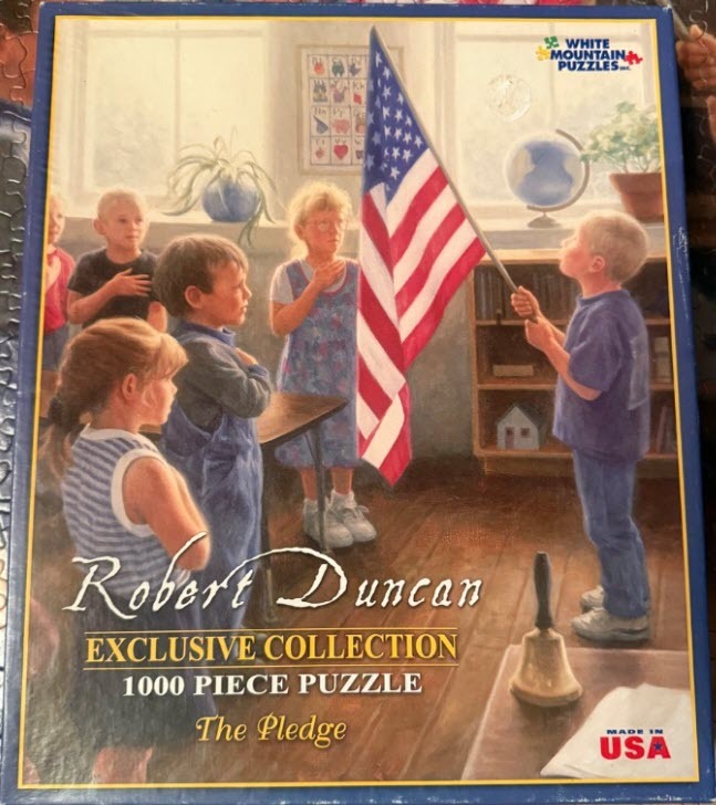 Children standing in a classroom saying the Pledge of Allegiance to an American flag.