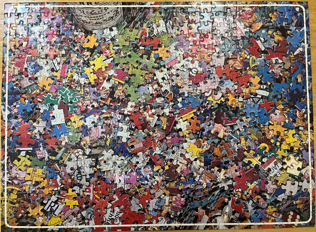 A dense collage of colorful comic book characters, signs, and assorted objects in a chaotic, detailed illustration.