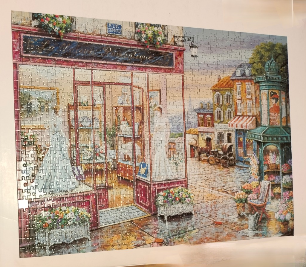 A charming Parisian boutique storefront with a street scene in the background.