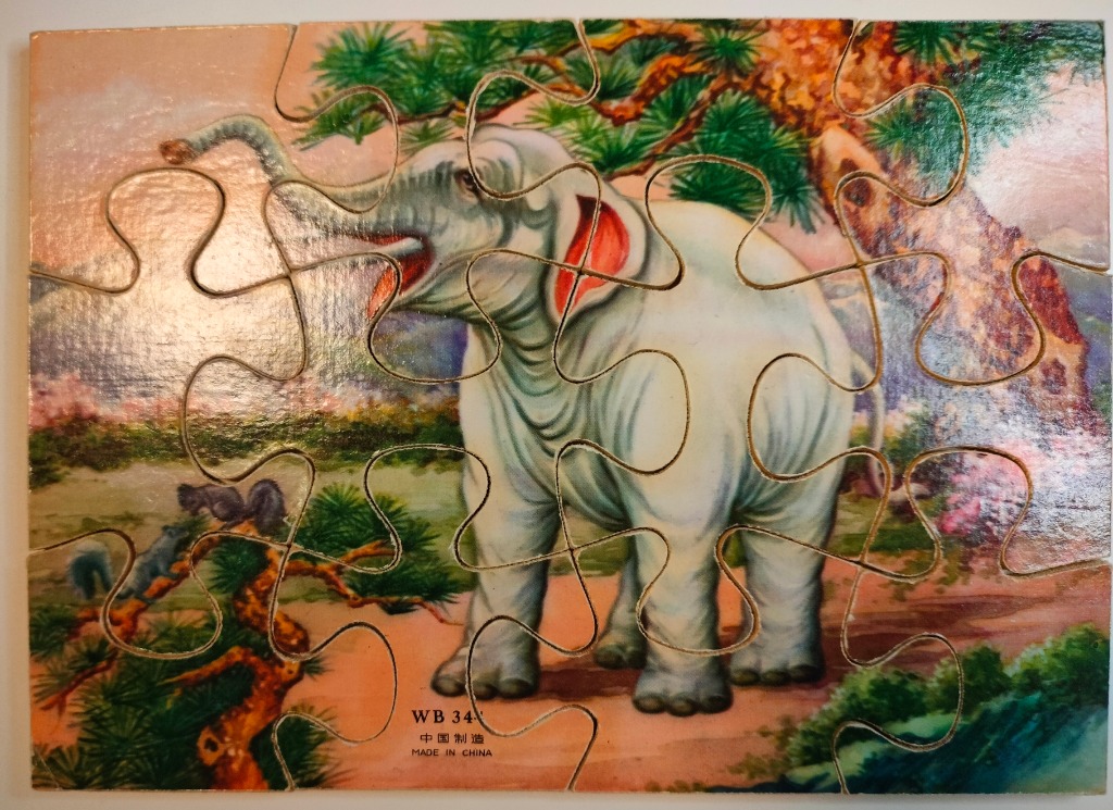 An illustration of a light grey elephant in a stylized landscape with a pine tree and rocky outcrop.