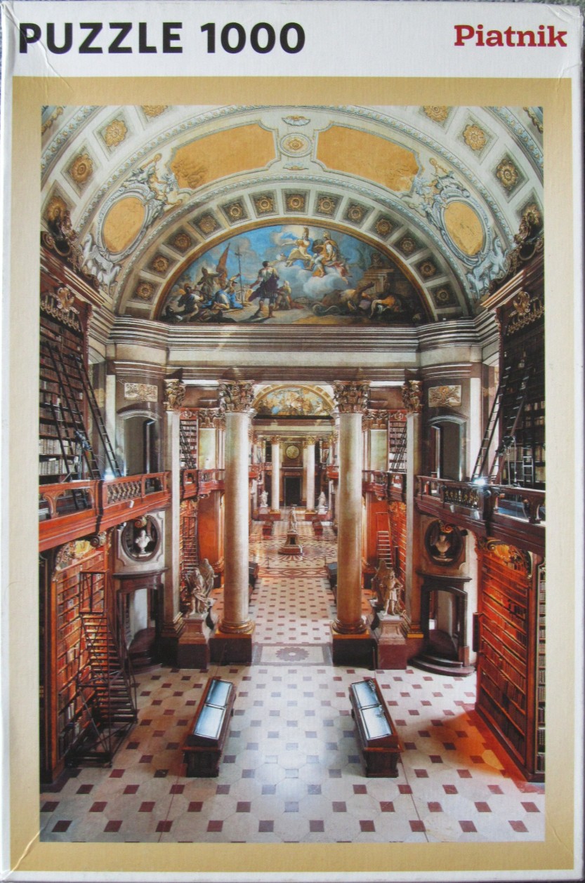 Interior view of the Melk Abbey Library featuring ornate pillars, tiered bookshelves, and a painted arched ceiling.