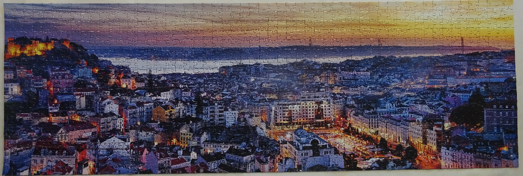 Panoramic twilight view of Lisbon, Portugal, featuring the illuminated São Jorge Castle and the cityscape.