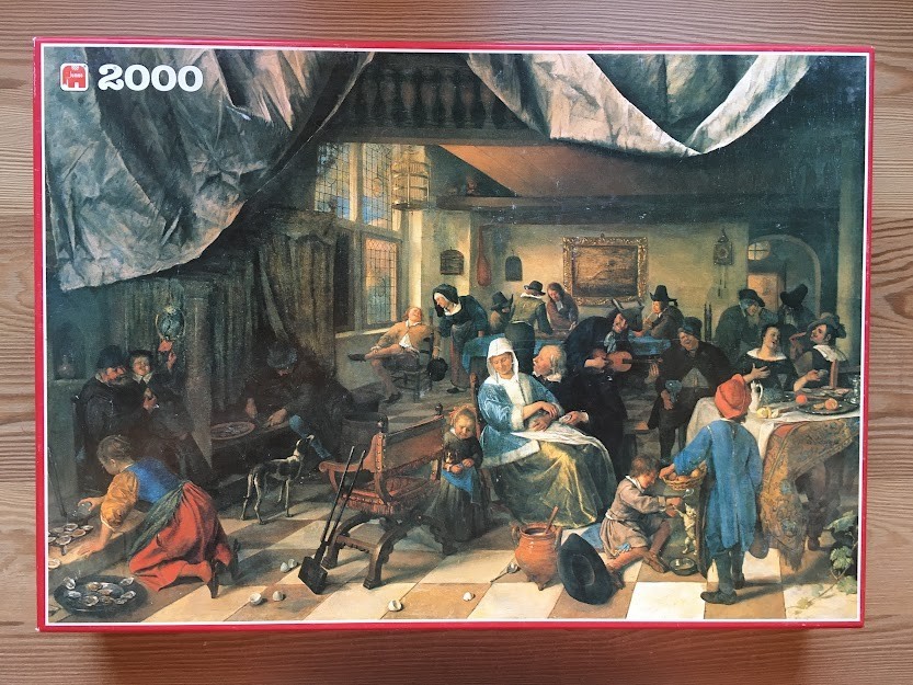 A 17th-century Dutch tavern scene showing a large group of people drinking, eating, and interacting indoors.