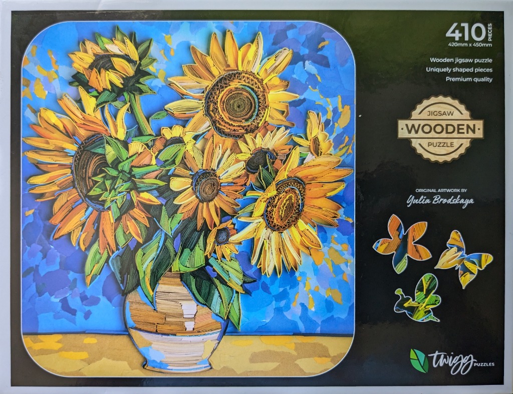 A vibrant paper-quilling artwork of sunflowers in a vase against a blue, textured background.