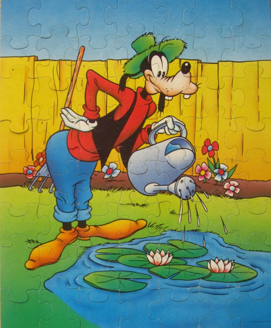 Goofy the cartoon character watering a lily pond in a backyard garden.